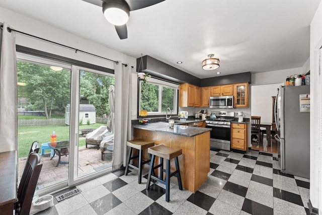 281 S Western Ave, Bartlett, IL 60103 - kitchen with appliances with stainless steel finishes, a peninsula, ceiling fan, dark countertops, and glass insert cabinets