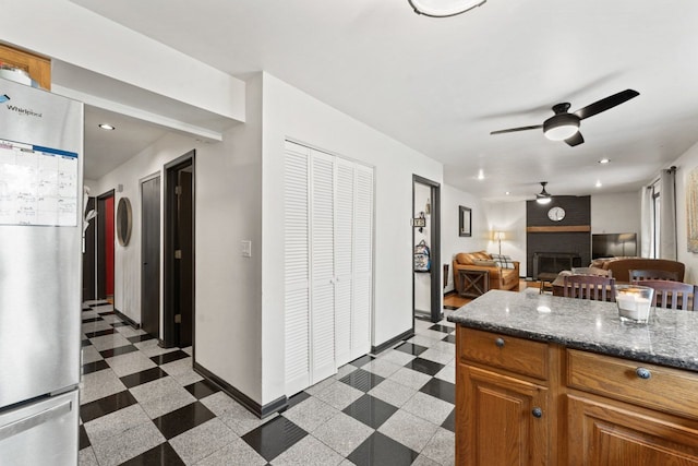 281 S Western Ave, Bartlett, IL 60103 - kitchen with freestanding refrigerator, a ceiling fan, a brick fireplace, dark stone countertops, and light floors