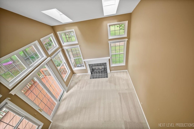 1348 Averill Cir, Geneva, IL 60134 - unfurnished living room featuring a skylight, high vaulted ceiling, a tile fireplace, and carpet flooring