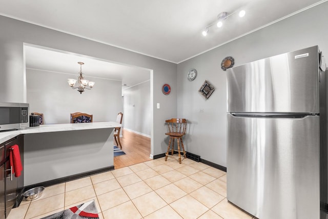 6411 W 88th St, Oak Lawn, IL 60453 - kitchen with appliances with stainless steel finishes, light countertops, light tile patterned floors, a chandelier, and crown molding