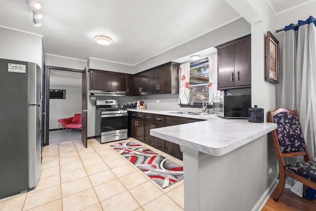 6411 W 88th St, Oak Lawn, IL 60453 - kitchen with stainless steel appliances, a peninsula, dark brown cabinetry, under cabinet range hood, and a kitchen bar