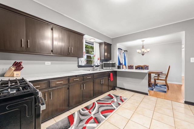 6411 W 88th St, Oak Lawn, IL 60453 - kitchen with stainless steel microwave, dark brown cabinets, a chandelier, light tile patterned floors, and ornamental molding