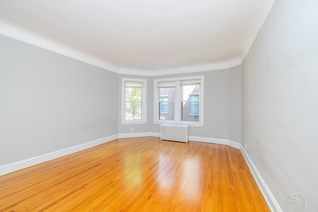 6751 N Artesian Ave Unit 2C, Chicago, IL 60645 - spare room with radiator and light wood-style flooring