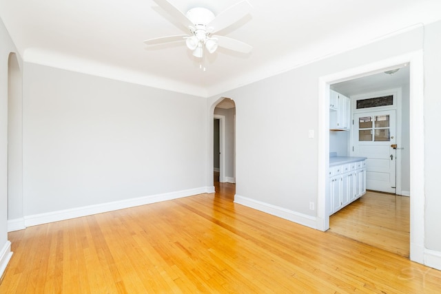 6751 N Artesian Ave Unit 2C, Chicago, IL 60645 - unfurnished room with arched walkways, ceiling fan, and light wood finished floors