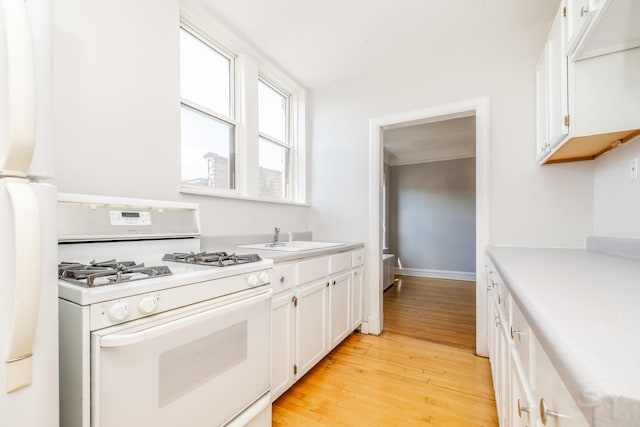 6751 N Artesian Ave Unit 2C, Chicago, IL 60645 - kitchen featuring white range with gas cooktop, light wood-type flooring, white cabinetry, and light countertops