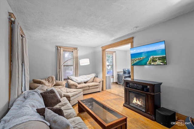263 W Illinois Ave, Aurora, IL 60506 - living room featuring a glass covered fireplace, light wood-style floors, and a textured ceiling