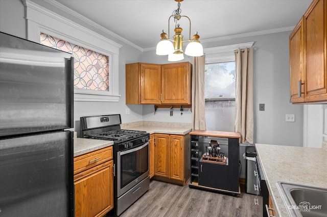 263 W Illinois Ave, Aurora, IL 60506 - kitchen featuring appliances with stainless steel finishes, light countertops, light wood-style floors, a chandelier, and brown cabinetry