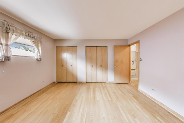 5215 S Meade Ave, Chicago, IL 60638 - unfurnished bedroom featuring multiple closets and light wood-type flooring