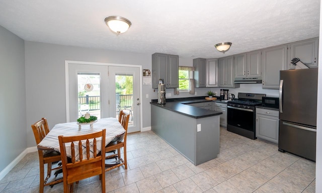 165 E Clay St, El Paso, IL 61738 - kitchen featuring stainless steel appliances, gray cabinetry, under cabinet range hood, dark countertops, and a peninsula