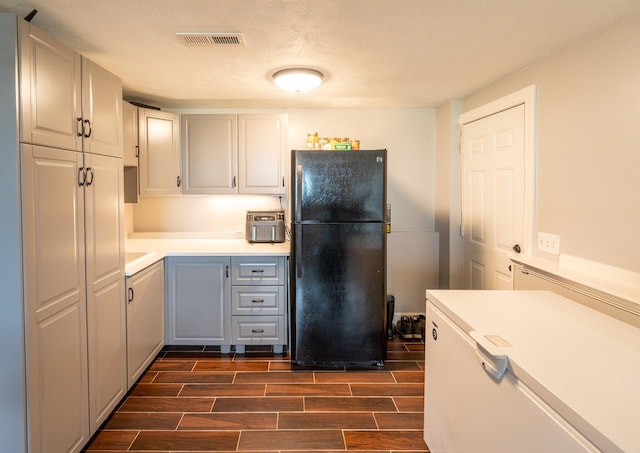 165 E Clay St, El Paso, IL 61738 - kitchen featuring freestanding refrigerator, fridge, light countertops, wood finish floors, and gray cabinetry