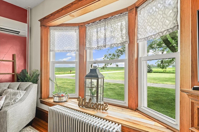 887 N 1100e Rd, Melvin, IL 60952 - sunroom with radiator heating unit, an AC wall unit, and wood finished floors