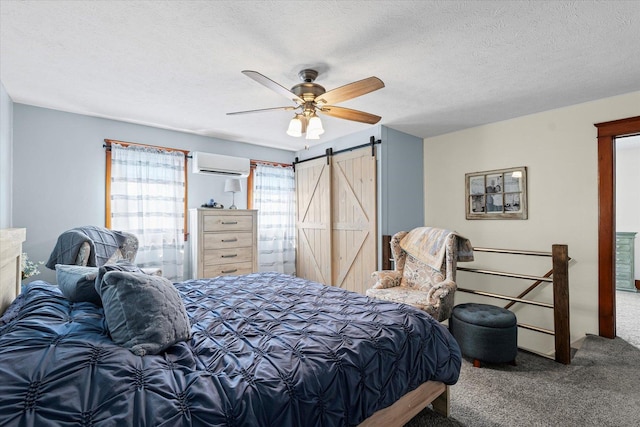 887 N 1100e Rd, Melvin, IL 60952 - carpeted bedroom with a wall mounted AC, a barn door, a textured ceiling, and ceiling fan