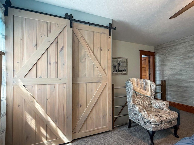 887 N 1100e Rd, Melvin, IL 60952 - sitting room featuring a barn door, carpet, a ceiling fan, a textured ceiling, and wooden walls