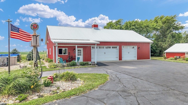 887 N 1100e Rd, Melvin, IL 60952 - view of front facade with a metal roof, a garage, and a chimney