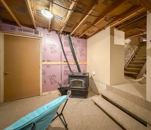 887 N 1100e Rd, Melvin, IL 60952 - unfinished below grade area featuring carpet flooring, a wood stove, and stairs