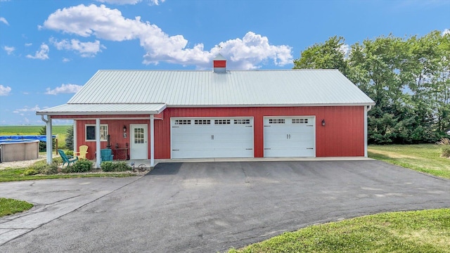 887 N 1100e Rd, Melvin, IL 60952 - view of front of property featuring a metal roof, a detached garage, and a porch