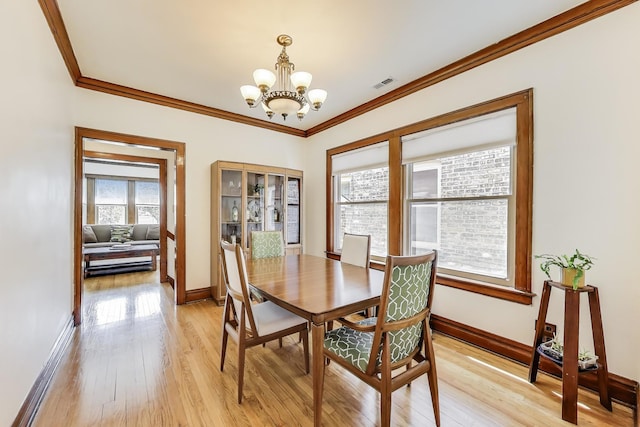 3740 N Whipple St, Chicago, IL 60618 - dining area featuring a chandelier, crown molding, and light wood-style floors