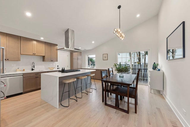 787 Bluejay Cir, Elk Grove Village, IL 60007 - kitchen featuring stainless steel dishwasher, wall chimney exhaust hood, a center island, a breakfast bar area, and light countertops
