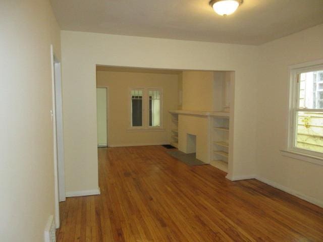 7522 S Merrill Ave, Chicago, IL 60649 - unfurnished living room with wood finished floors and a fireplace with flush hearth