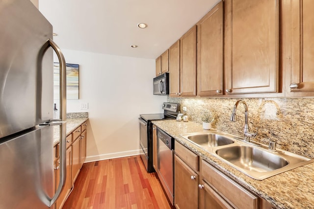 30 E Huron St Unit 2602, Chicago, IL 60611 - kitchen featuring stainless steel appliances, light wood-type flooring, decorative backsplash, brown cabinets, and recessed lighting