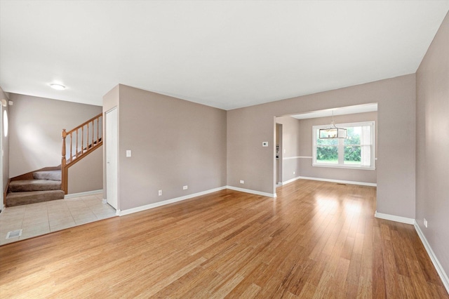1097 Dovercliff Way, Crystal Lake, IL 60014 - unfurnished living room with light wood-style floors, stairs, and a chandelier