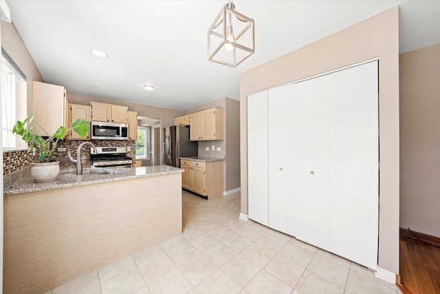 1097 Dovercliff Way, Crystal Lake, IL 60014 - kitchen with stainless steel appliances, tasteful backsplash, a peninsula, light tile patterned flooring, and light stone countertops