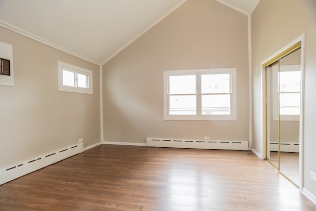 1103 Circle Ave, Forest Park, IL 60130 - unfurnished bedroom featuring a baseboard heating unit, ornamental molding, vaulted ceiling, and wood finished floors