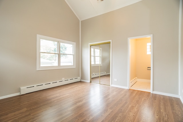 1103 Circle Ave, Forest Park, IL 60130 - unfurnished bedroom with a baseboard radiator, high vaulted ceiling, a baseboard heating unit, wood finished floors, and a closet