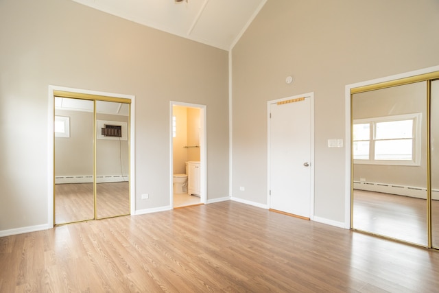 1103 Circle Ave, Forest Park, IL 60130 - unfurnished bedroom featuring high vaulted ceiling, a baseboard heating unit, wood finished floors, and two closets