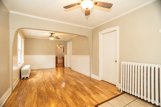 1103 Circle Ave, Forest Park, IL 60130 - empty room with radiator heating unit, arched walkways, a ceiling fan, and crown molding