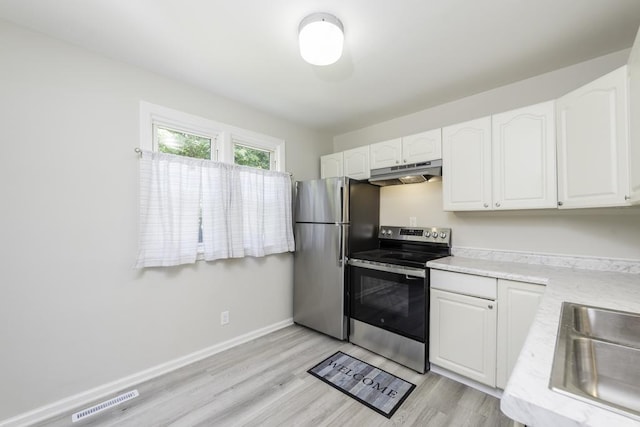 542 Whitney Ave, Winthrop Harbor, IL 60096 - kitchen with stainless steel appliances, under cabinet range hood, white cabinets, light countertops, and light wood-type flooring