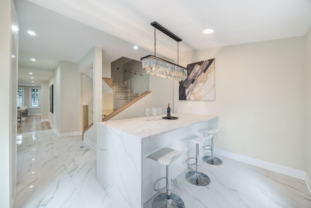 4143 N Drake Ave, Chicago, IL 60618 - kitchen featuring light marble finish floors, recessed lighting, a kitchen breakfast bar, and light stone countertops