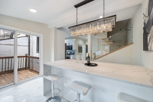 4143 N Drake Ave, Chicago, IL 60618 - kitchen with appliances with stainless steel finishes, light marble finish floors, white cabinetry, light stone counters, and pendant lighting