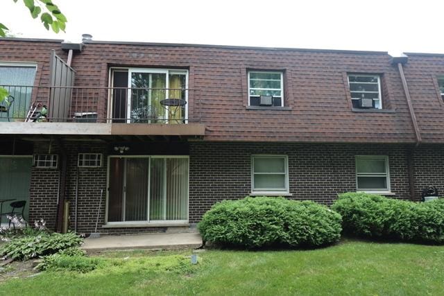 815 Grove Dr Unit 112, Buffalo Grove, IL 60089 - rear view of property with mansard roof, a balcony, brick siding, and a yard