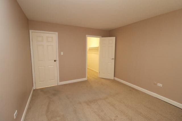 815 Grove Dr Unit 112, Buffalo Grove, IL 60089 - unfurnished bedroom featuring carpet floors, a walk in closet, and a closet