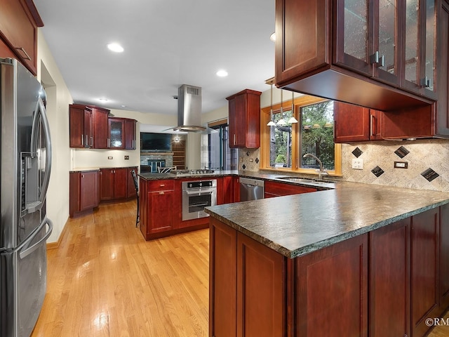 780 Chisholm Trl, Roselle, IL 60172 - kitchen featuring appliances with stainless steel finishes, a peninsula, island exhaust hood, dark countertops, and reddish brown cabinets