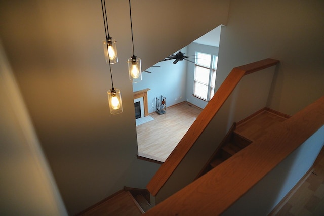 182 Cherrywood Ct, Romeoville, IL 60446 - stairway with wood finished floors, a ceiling fan, and a fireplace with flush hearth