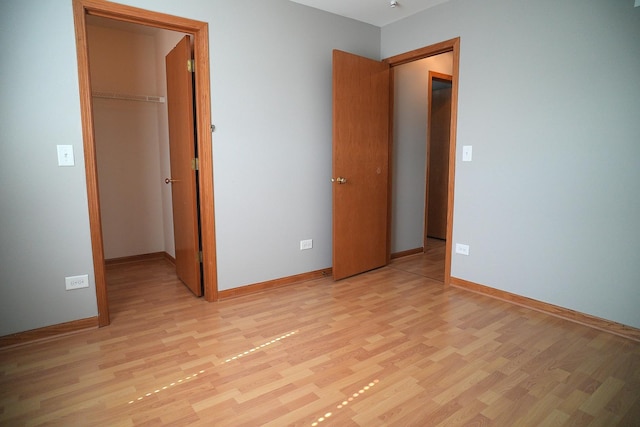 182 Cherrywood Ct, Romeoville, IL 60446 - unfurnished bedroom with light wood-style floors, a walk in closet, and a closet