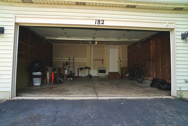 182 Cherrywood Ct, Romeoville, IL 60446 - garage featuring heating unit, a garage door opener, and driveway