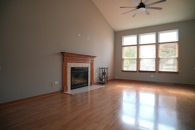 182 Cherrywood Ct, Romeoville, IL 60446 - unfurnished living room featuring healthy amount of natural light, ceiling fan, a tiled fireplace, high vaulted ceiling, and wood finished floors
