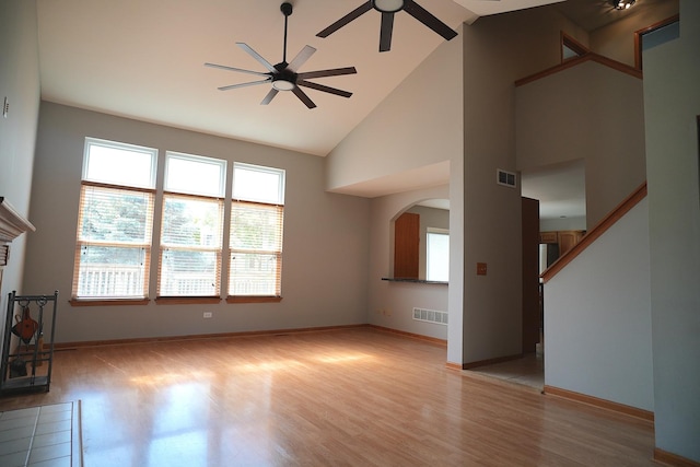 182 Cherrywood Ct, Romeoville, IL 60446 - unfurnished living room featuring ceiling fan, wood finished floors, arched walkways, high vaulted ceiling, and a fireplace