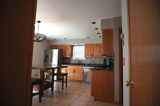 182 Cherrywood Ct, Romeoville, IL 60446 - kitchen featuring stainless steel appliances, backsplash, dark countertops, a chandelier, and light tile patterned floors