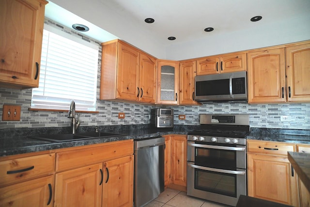 182 Cherrywood Ct, Romeoville, IL 60446 - kitchen featuring stainless steel appliances, decorative backsplash, light tile patterned flooring, glass insert cabinets, and dark stone countertops