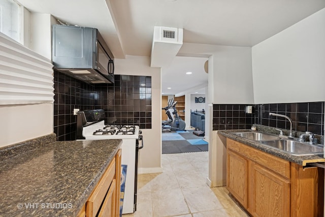 463 N Elm St, Hillside, IL 60162 - kitchen featuring white gas stove, light tile patterned floors, decorative backsplash, brown cabinetry, and recessed lighting