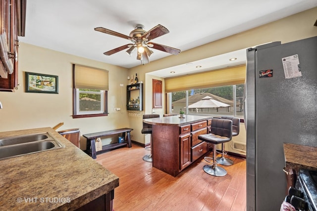 463 N Elm St, Hillside, IL 60162 - kitchen with freestanding refrigerator, ceiling fan, light wood-type flooring, a kitchen breakfast bar, and light countertops