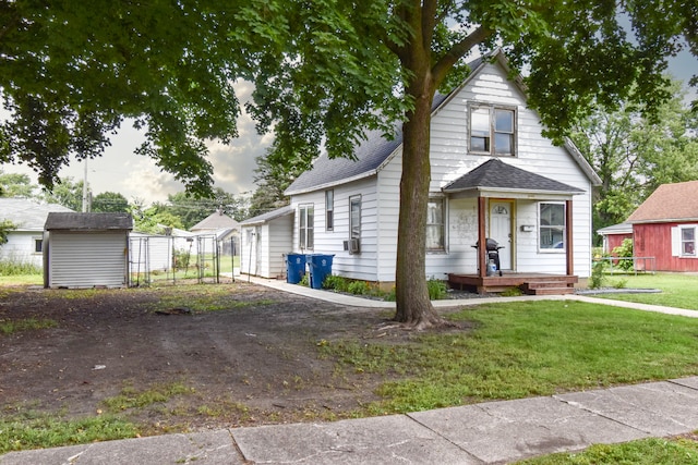 222 W S St, Dwight, IL 60420 - view of front of home with a front lawn, a shingled roof, and a shed