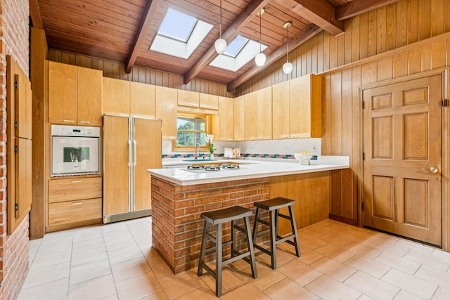 205 Sherwood Rd, Elgin, IL 60120 - kitchen with paneled built in refrigerator, oven, a skylight, wooden ceiling, and light countertops