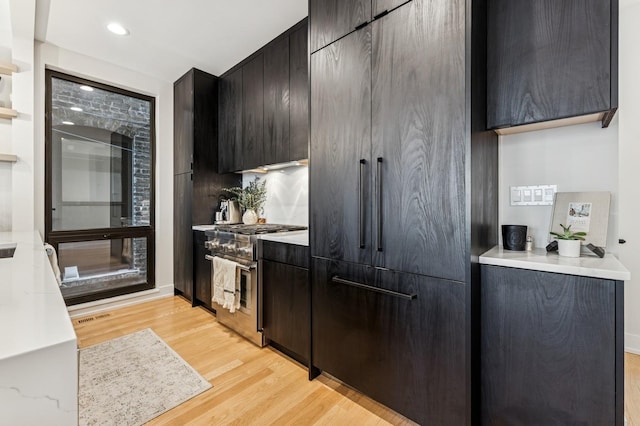 1423 W Huron St Unit 1, Chicago, IL 60642 - kitchen with light wood-style floors, stainless steel stove, light countertops, recessed lighting, and modern cabinets
