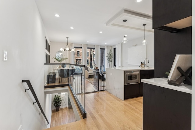 1423 W Huron St Unit 1, Chicago, IL 60642 - kitchen with light wood finished floors, light countertops, pendant lighting, stainless steel oven, and recessed lighting