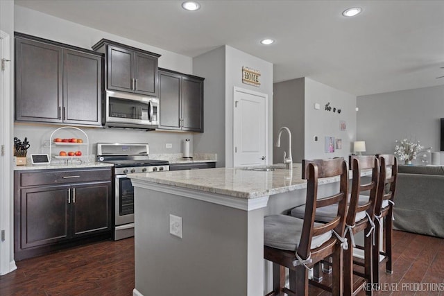 2267 Lundquist Dr, Aurora, IL 60503 - kitchen featuring stainless steel appliances, dark wood-style floors, light stone countertops, a breakfast bar area, and recessed lighting